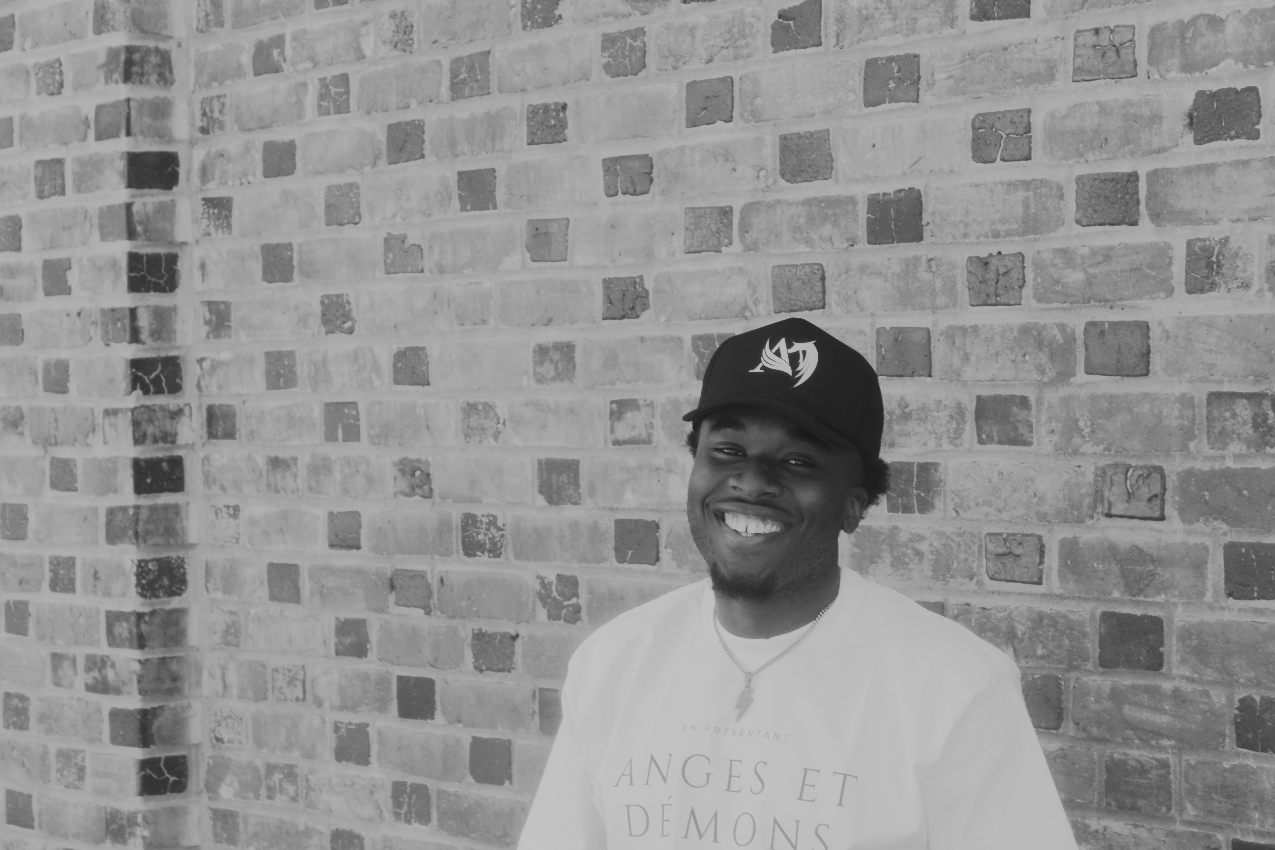 Standing in front of a brick wall,

 